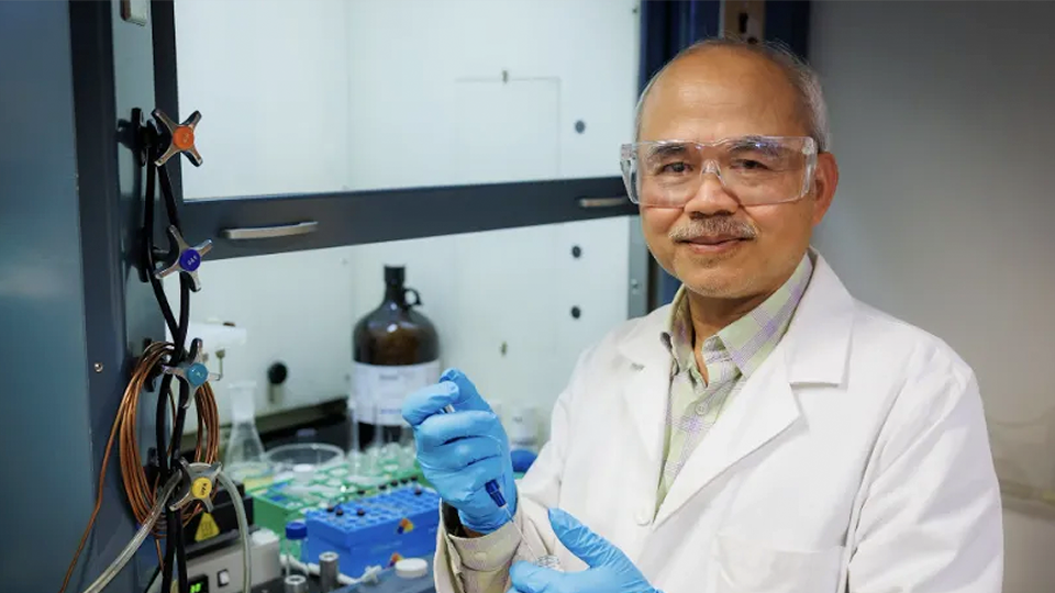 Researcher in lab holding a vial