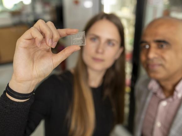 Two Georgia Tech researchers looking at a biomedical chip.