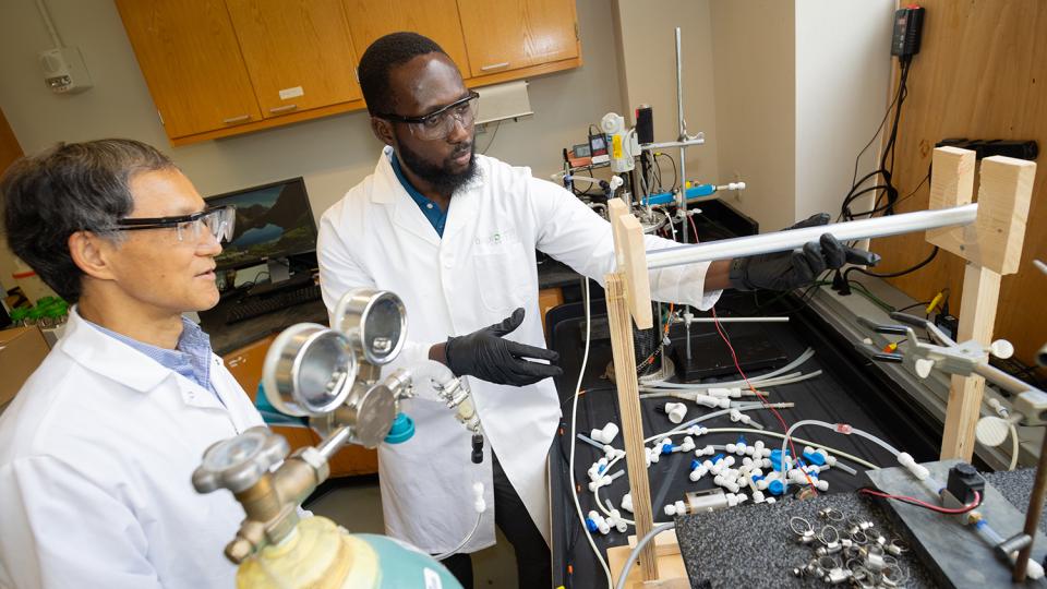Ahmed Yunus and Yongsheng Chen working with a wastewater reactor system in the lab.
